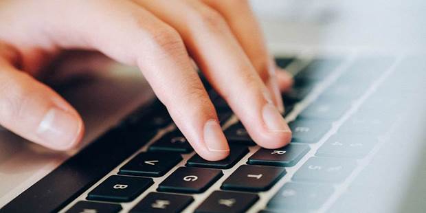 Feminine hands on laptop keyboard