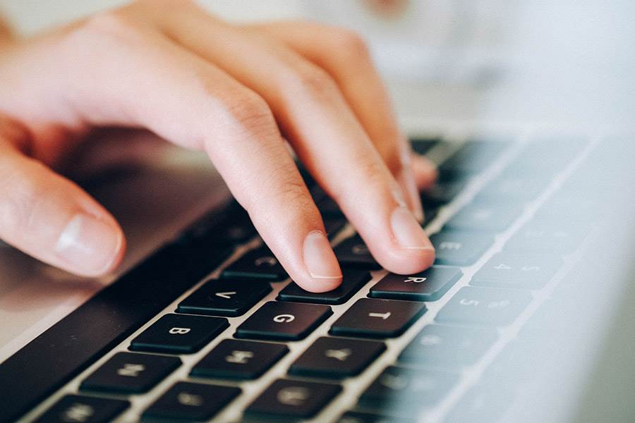 Feminine hands on laptop keyboard