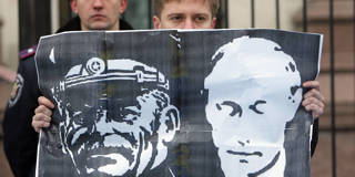 Protestor holds a flag with Stalin and Putin on it.