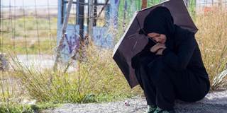 Syrian woman under umbrella.