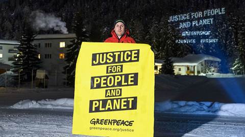 A Greenpeace activist holds a placard