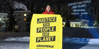 A Greenpeace activist holds a placard