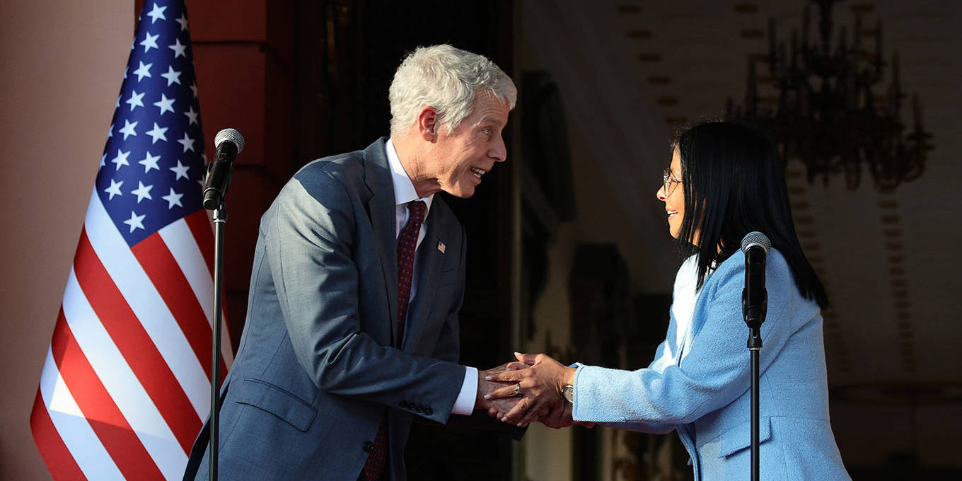 Delcy Rodriguez and the US energy secretary shake hands