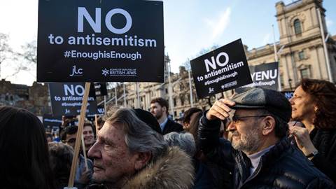 Protesters hold placards as they demonstrate in Parliament Square against anti-Semitism