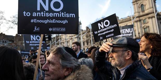 Protesters hold placards as they demonstrate in Parliament Square against anti-Semitism