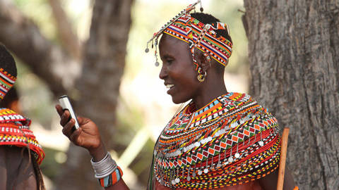 Samburu woman uses mobile phone in North Kenya before Lake Turkana Festival
