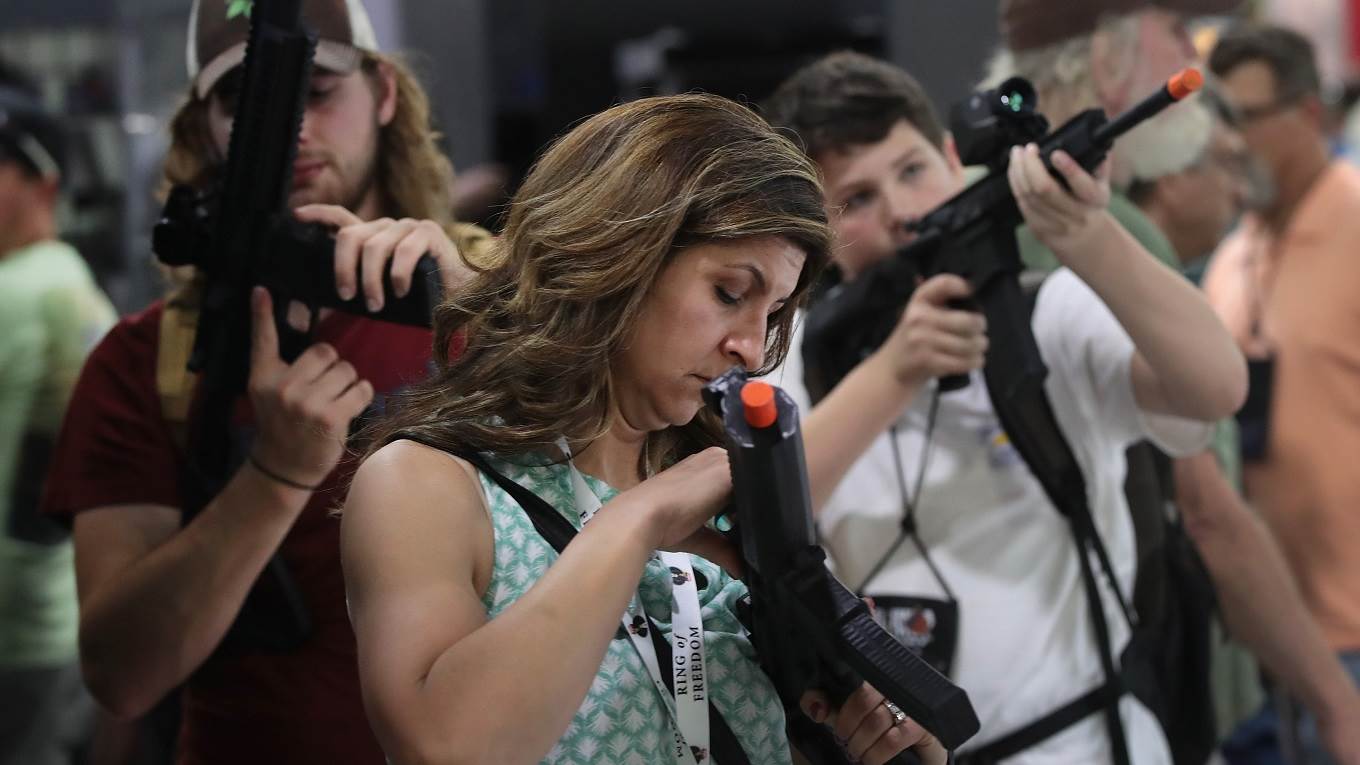 National Rifle Association members look over optics in the SIG Sauer display