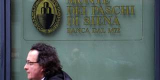 A man walks past a branch of the Monte dei Paschi di Siena bank