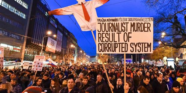 Protesters holds placards during a rally against corruption and to pay tribute to murdered Slovak journalist Jan Kuciak