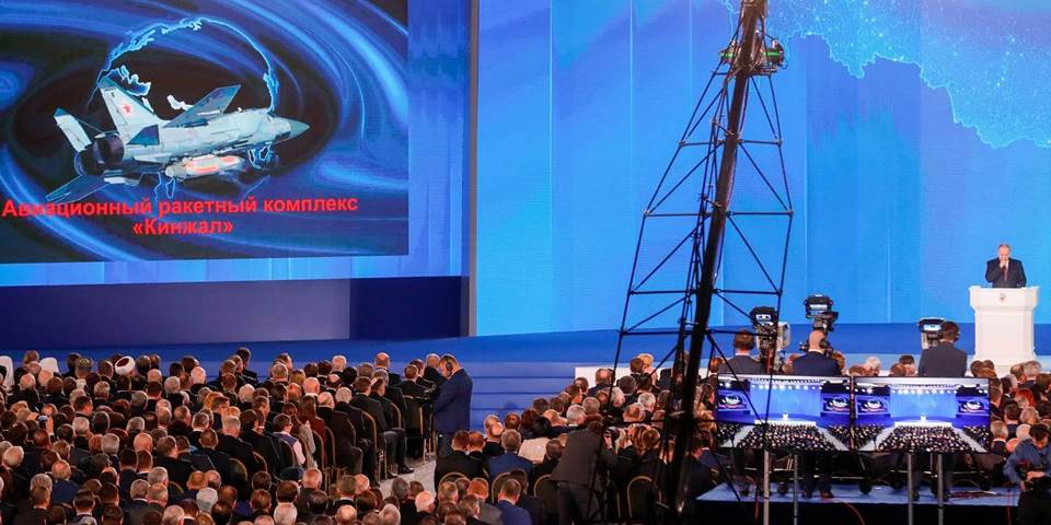 The video screen shows the Kinzhal shipborne surface-to-air missile system as Putin delivers an annual address to the Federal Assembly