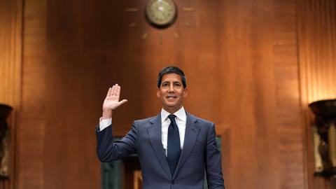 Kevin Warsh, President Donald Trump’s nominee for Chair of the Federal Reserve, raises his right hand while being sworn in before the Senate Committee on Banking, Housing, and Urban Affairs during his confirmation hearing in the Dirksen Senate Office Building in Washington, D.C., on April 21, 2026. Seated at a witness table, Warsh faces senators as he prepares to testify regarding his nomination to succeed Jerome Powell. The hearing takes place amid bipartisan scrutiny related to a Justice Department investigation involving the current Federal Reserve chair.