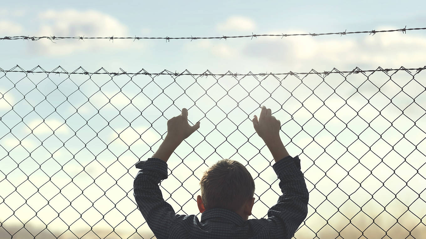 legrain28_GettyImages_boysilhouetteholdingfence