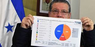 The president of Honduras' Supreme Electoral Tribunal shows the results of the recount of votes