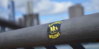 Refugees Welcome sticker on city handrail