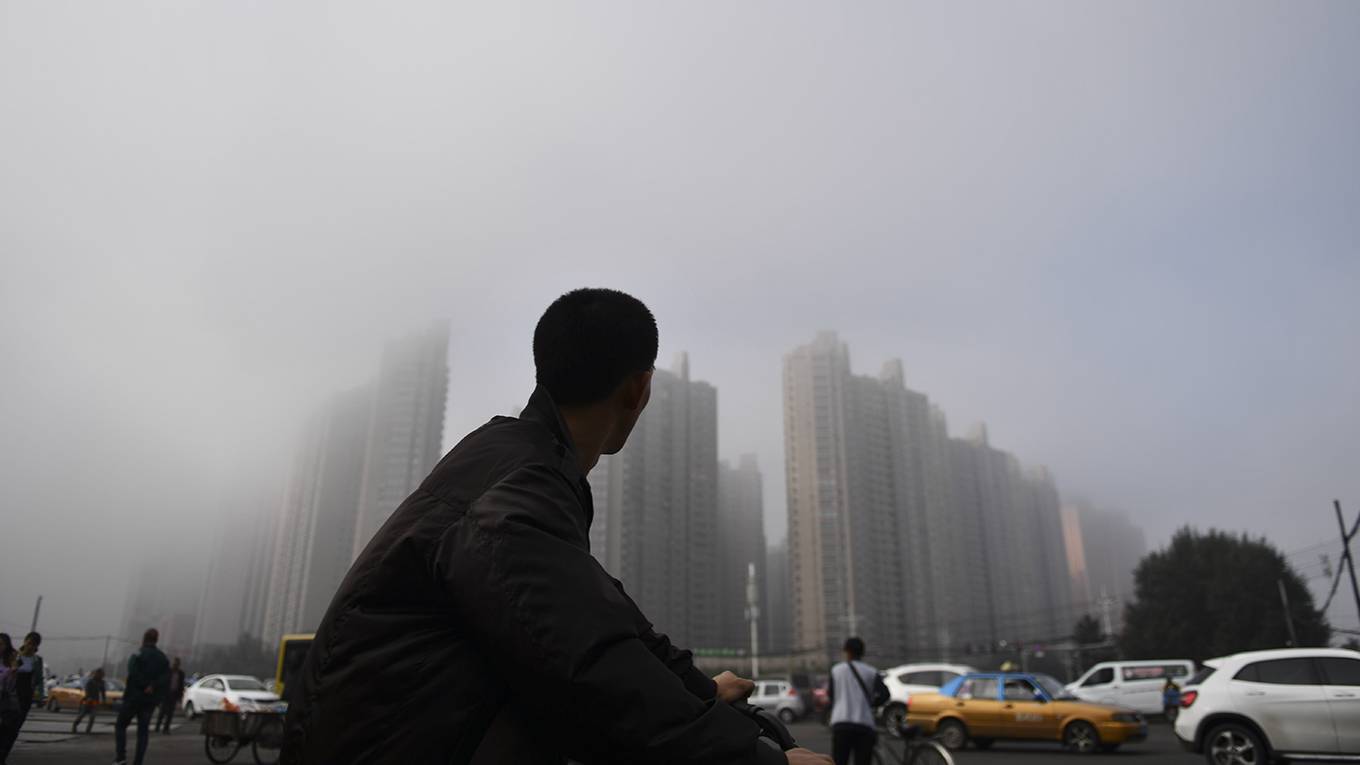 biswas12_TaoZhangGettyImages_bikeriderlooksatchinasmog
