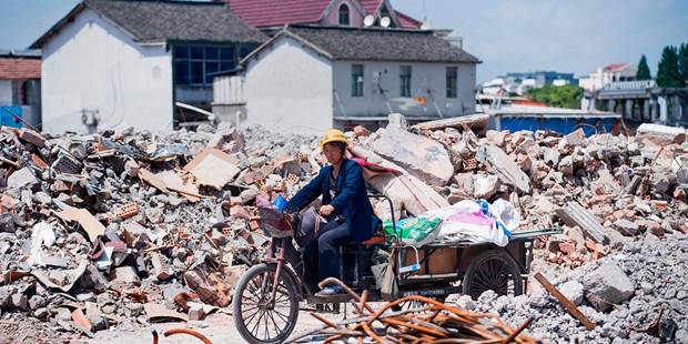 A migrant worker on her tricycle at the demolition site of the Jiuxing furniture market 