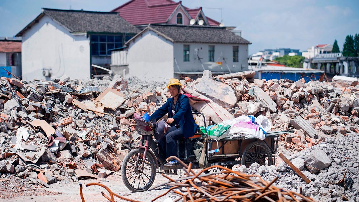 A migrant worker on her tricycle at the demolition site of the Jiuxing furniture market