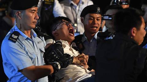 Pro-democracy activist Joshua Wong yells as he is taken away by police