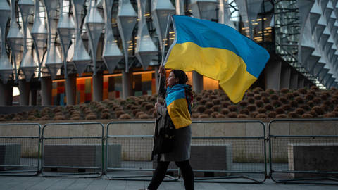 Woman carrying and wearing Ukraine flags in UK.