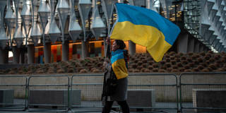 Woman carrying and wearing Ukraine flags in UK.