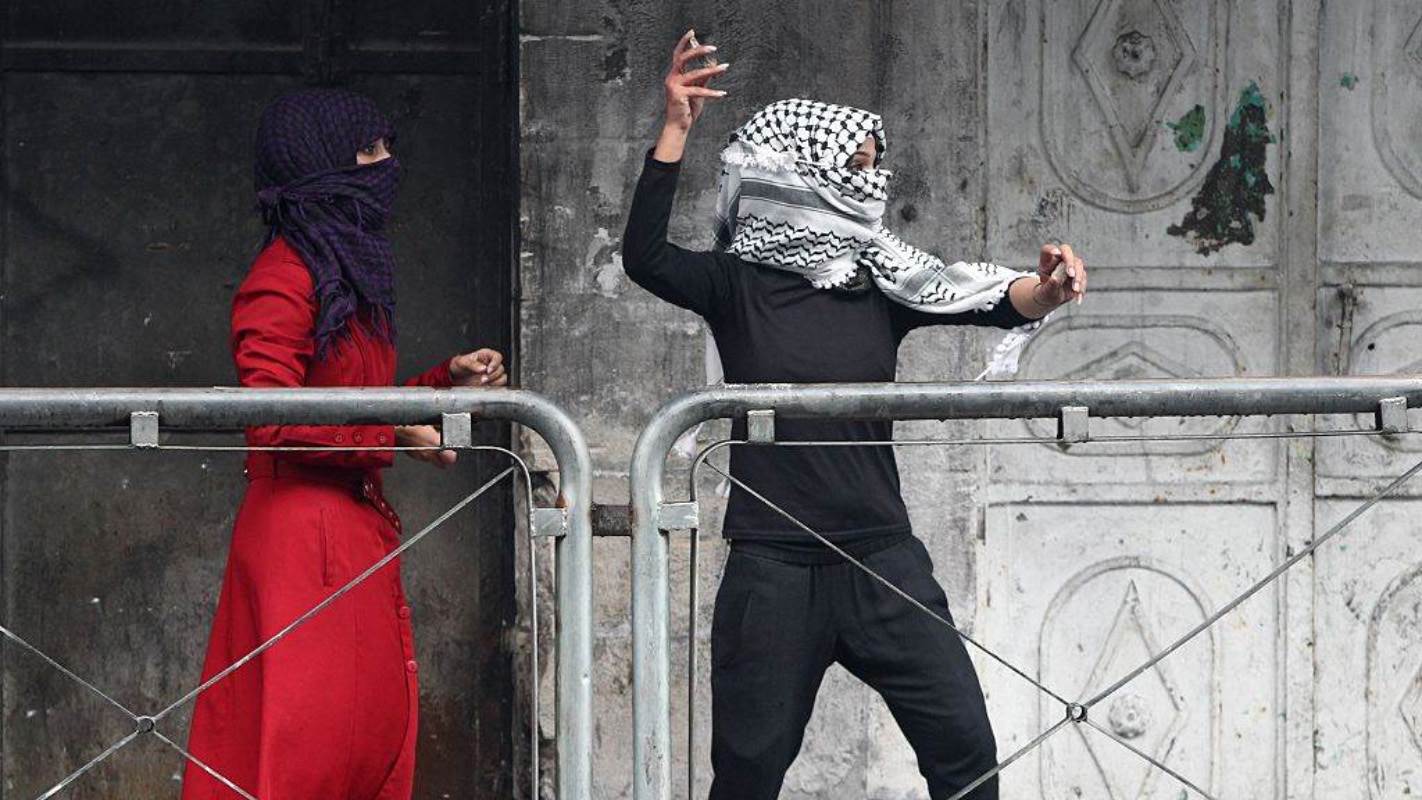 Palestianian women throw stones at Israeli security