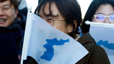 South Korean peace activists carry the Flag of Korean Peninsula