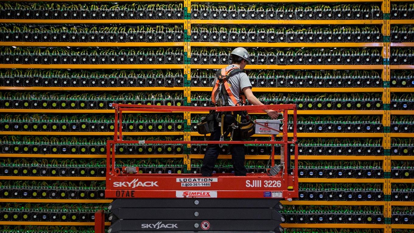 A technician inspects the backside of bitcoin mining at Bitfarms in Saint Hyacinthe