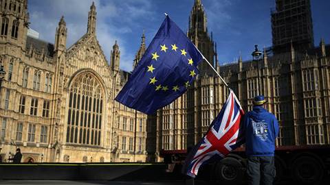 Anti-Brexit demonstrator holds the EU and UK flags outside the Houses of Parliament