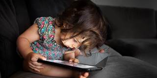 Toddler concentrated with a tablet
