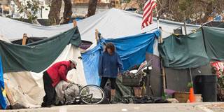 A homeless encampment made of tents and tarps lines the Santa Ana