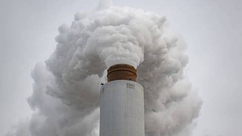 Flue-gas stack emitting smoke at the Kentucky Utilities Ghent coal-fired power plant in Ghent, Kentucky, February 14, 2026, illustrating U.S. coal industry emissions amid federal rollback of EPA greenhouse gas regulations.