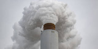 Flue-gas stack emitting smoke at the Kentucky Utilities Ghent coal-fired power plant in Ghent, Kentucky, February 14, 2026, illustrating U.S. coal industry emissions amid federal rollback of EPA greenhouse gas regulations.