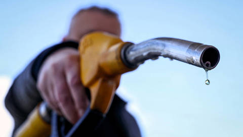 A drop of petrol hangs from the nozzle of a fuel pump at a petrol station in Vélizy-Villacoublay near Paris, illustrating rising global oil prices during the US-Israeli war with Iran.
