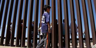 A boy from the Anapra area observes a binational prayer performed by a group of religious presbyters by migrants on the border wall