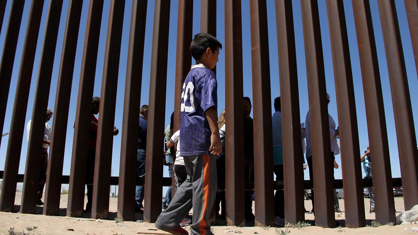 A boy from the Anapra area observes a binational prayer performed by a group of religious presbyters by migrants on the border wall