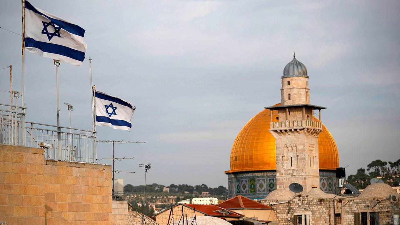 Israeli flags fly near the Dome of the Rock in the Al-Aqsa mosque compound