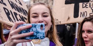  Two young girls seen taking selfies during the feminist demonstration