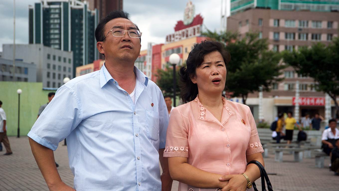 A man and a woman watch missile launch in Pyongyang