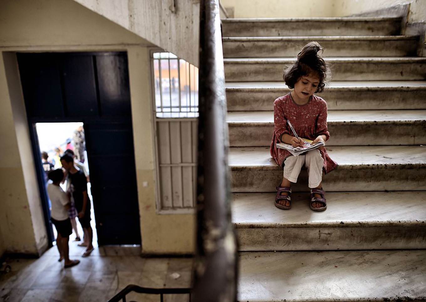 little girl draws greek refugee
