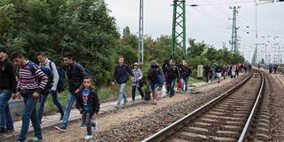 refugees walking along train tracks in Hungary
