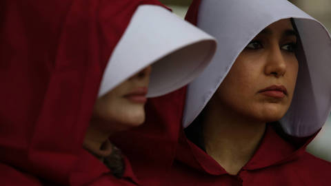 Iranian women’s rights activists dressed in Handmaid’s Tale red cloaks and white bonnets protest in London on November 8, 2024, marching from Parliament Square to Trafalgar Square in solidarity with Ahoo Daryaei, a 30-year-old Iranian student arrested after defying Iran’s morality police.