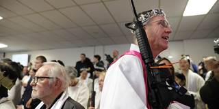 A church official holds an AR-15 rifle