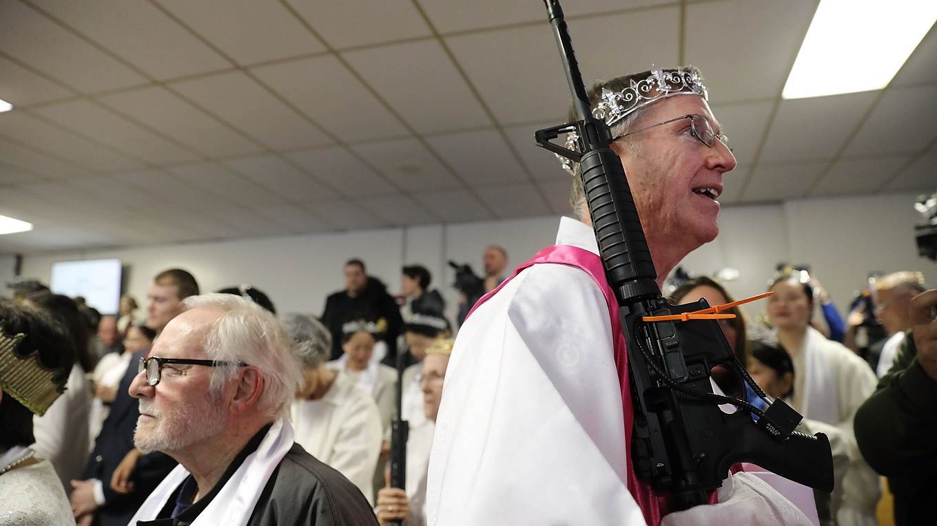 A church official holds an AR-15 rifle