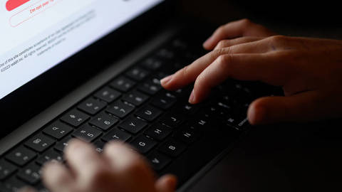 Teenage child looking at a laptop screen displaying age-restricted content, illustrating online safety concerns.