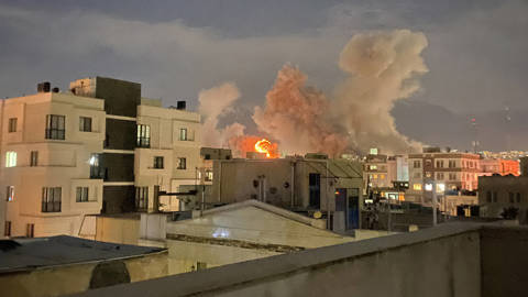 Plumes of smoke rising over Araqi Street in Tehran following explosions near Iran's Ministry of Intelligence on March 1, 2026, after the killing of Ayatollah Ali Khamenei, with streets and buildings partially obscured by smoke.