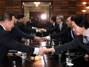 South Korean delegation (R) shakes hands with North Korean delegation (L)