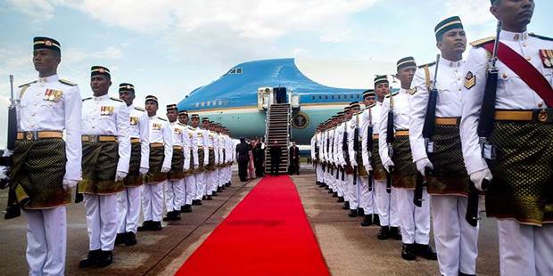 Air Force One on tarmac in Malaysia surrounded by royal-looking guards