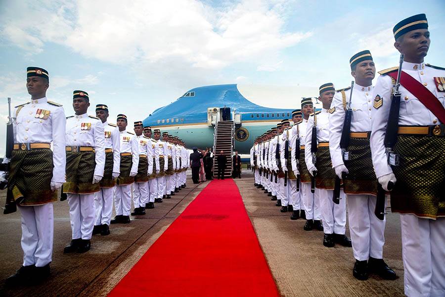 Air Force One on tarmac in Malaysia surrounded by royal-looking guards