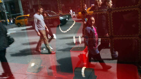 Pedestrians look at diamonds in a window display along 5th Avenue