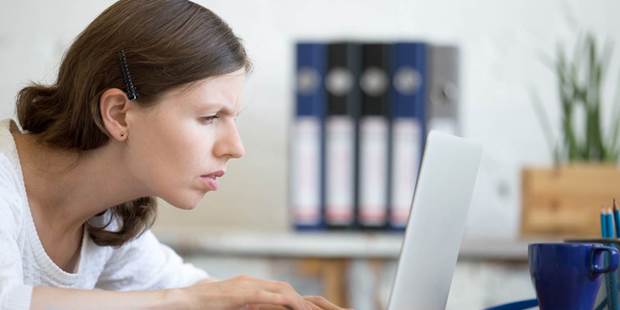 concerned woman looks at laptop